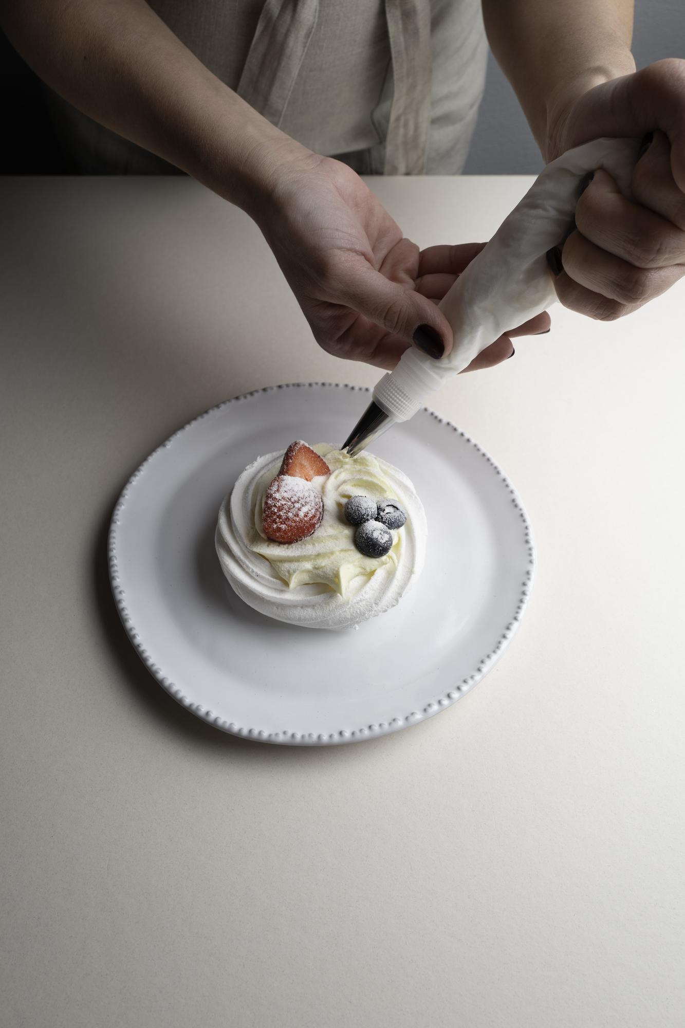Dettaglio mani che decorano un dolce