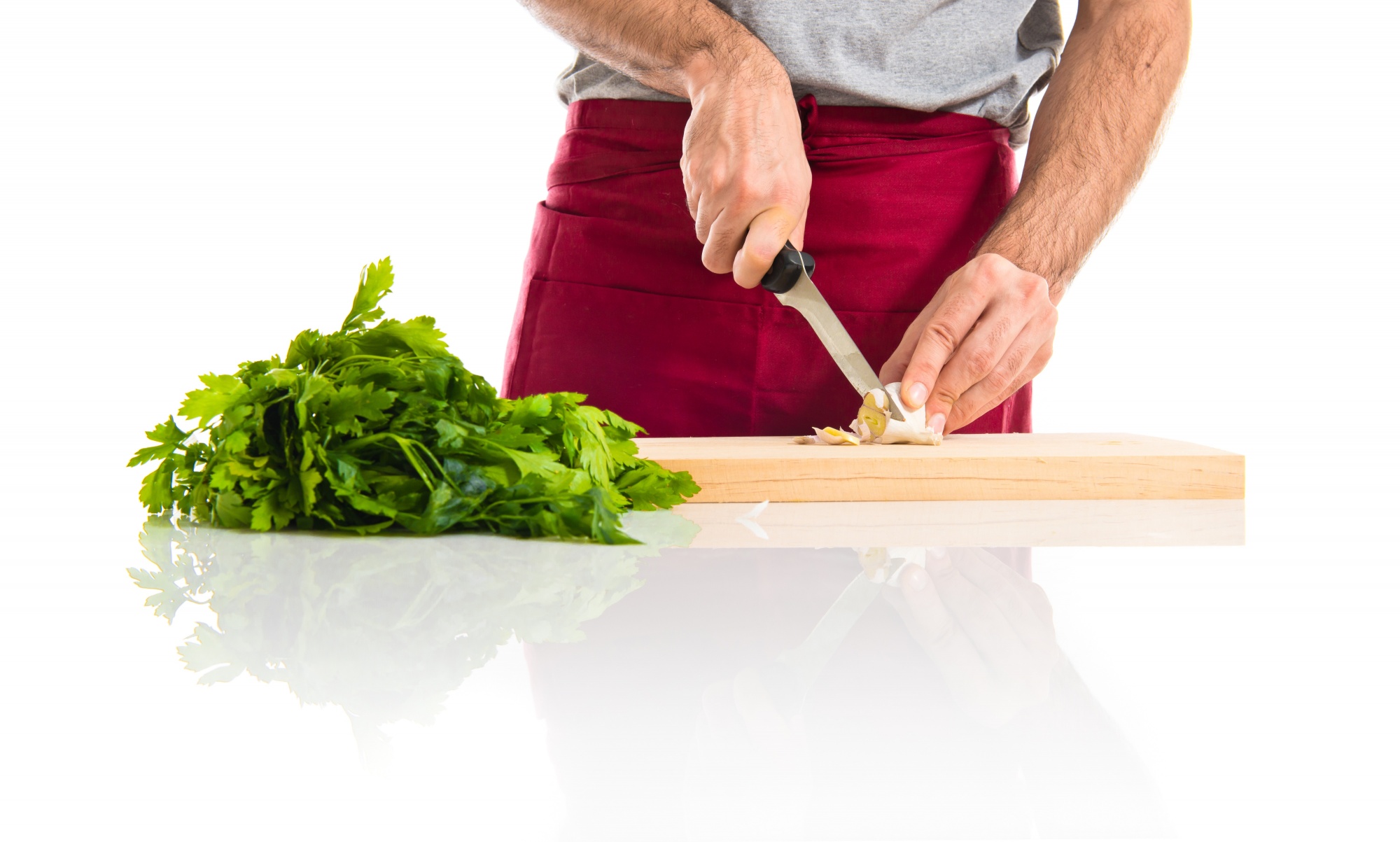 Chef che affetta con cura un ingrediente su tagliere in cucina elegante
